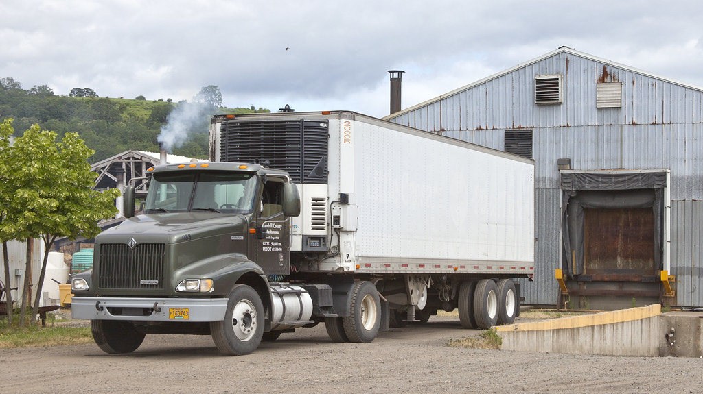 A Yamhill County Mushrooms refrigerated truck at the loading dock, backed up to the packing barn